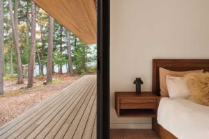 Ložnice s přímým vstupem na dřevěnou terasu mezi stromy
