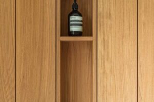 Detail vestavěné dřevěné skříňky s otevřenou nikou a minimalistickým řešením