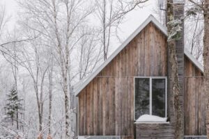 Rustikální silueta domu vystupuje ze sněhu s jemnou elegancí venkovské architektury.