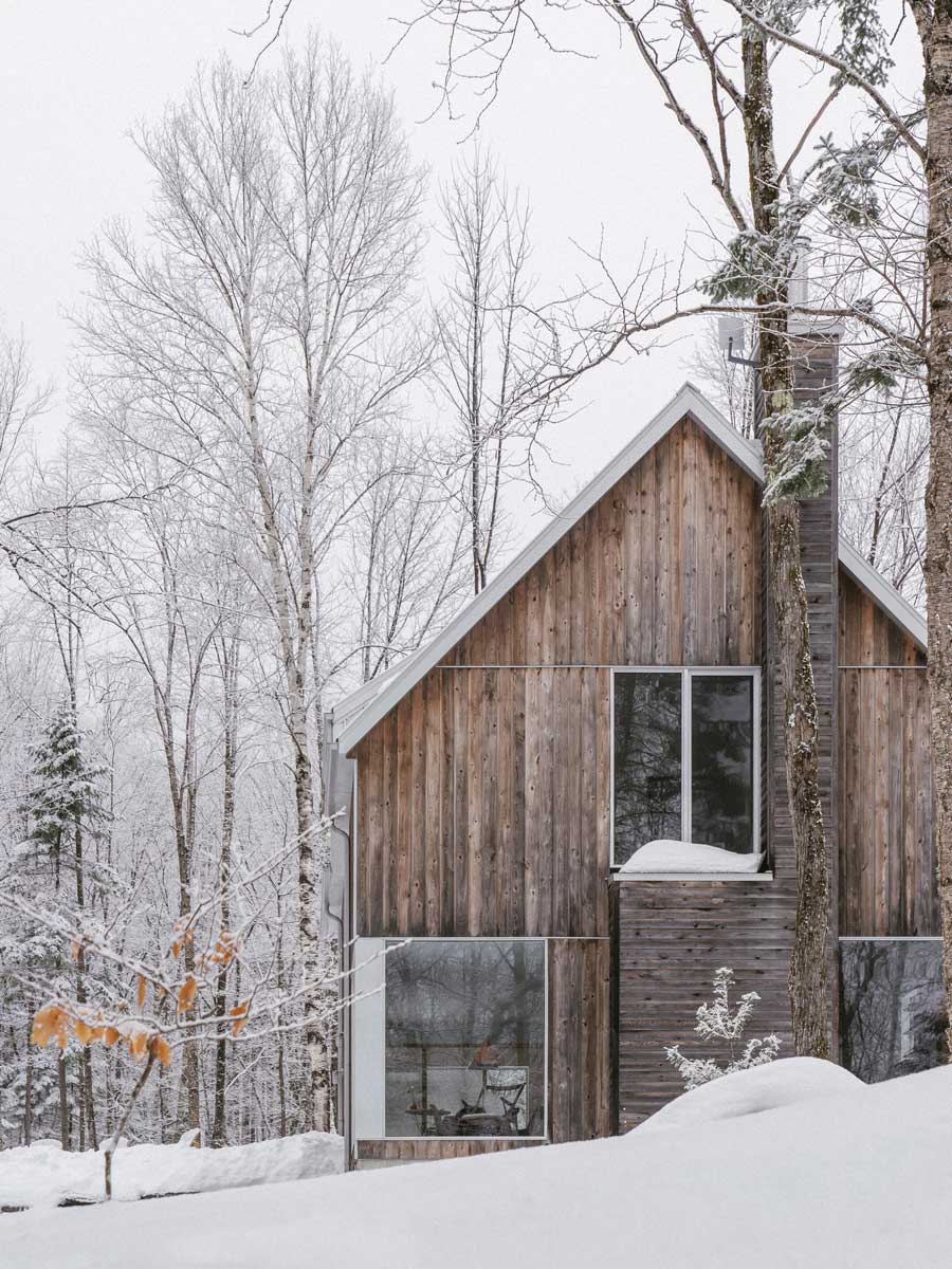 Rustikální silueta domu vystupuje ze sněhu s jemnou elegancí venkovské architektury.