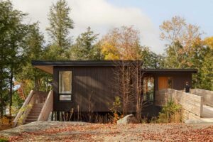 Moderní dům zasazený do lesa s horizontálními liniemi a dřevěným obkladem