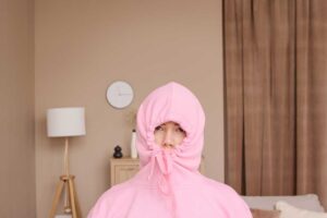 Žena schovaná v růžové mikině – symbol potřeby zimního klidu typického pro introverty.