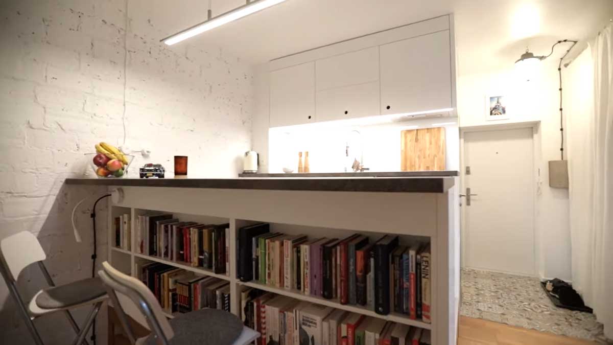 Jídelní pult s pracovní deskou a bílou knihovnou v podstavci.