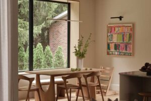 Dřevěný jídelní stůl u velkého okna s výhledem do zahrady