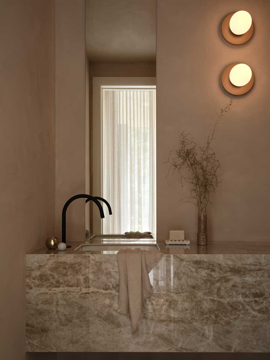 Detail černého kuchyňského kohoutku nad mramorovou deskou v minimalistickém interiéru