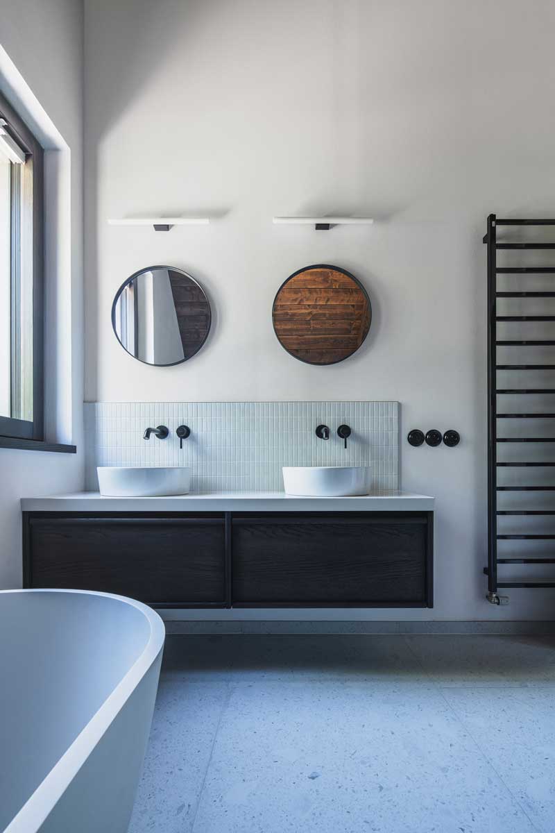 Moderní koupelna s vanou, dřevěnými prvky a čistými liniemi v horské chalupě