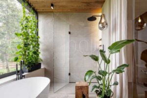 Designová koupelna s volně stojící vanou, sprchovým koutem a velkým oknem s rostlinami