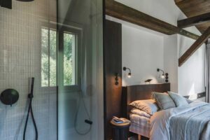 Koupelna v ložnici s volně stojícím umyvadlem a světlým obkladem