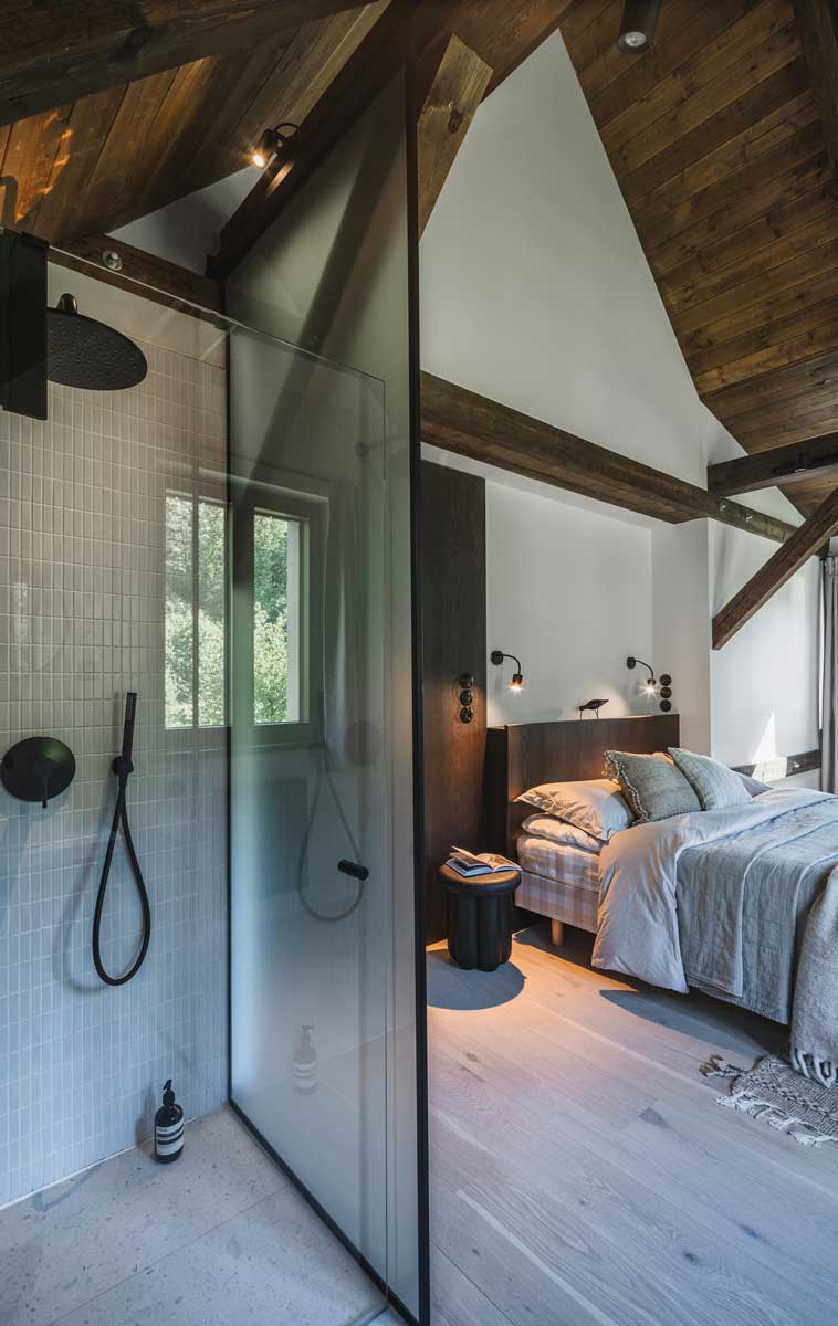 Koupelna v ložnici s volně stojícím umyvadlem a světlým obkladem