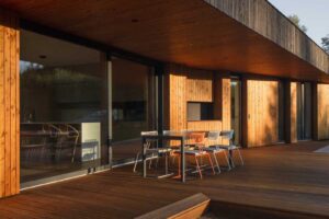 Dřevěná krytá terasa s posezením a přímým propojením na obytný prostor domu