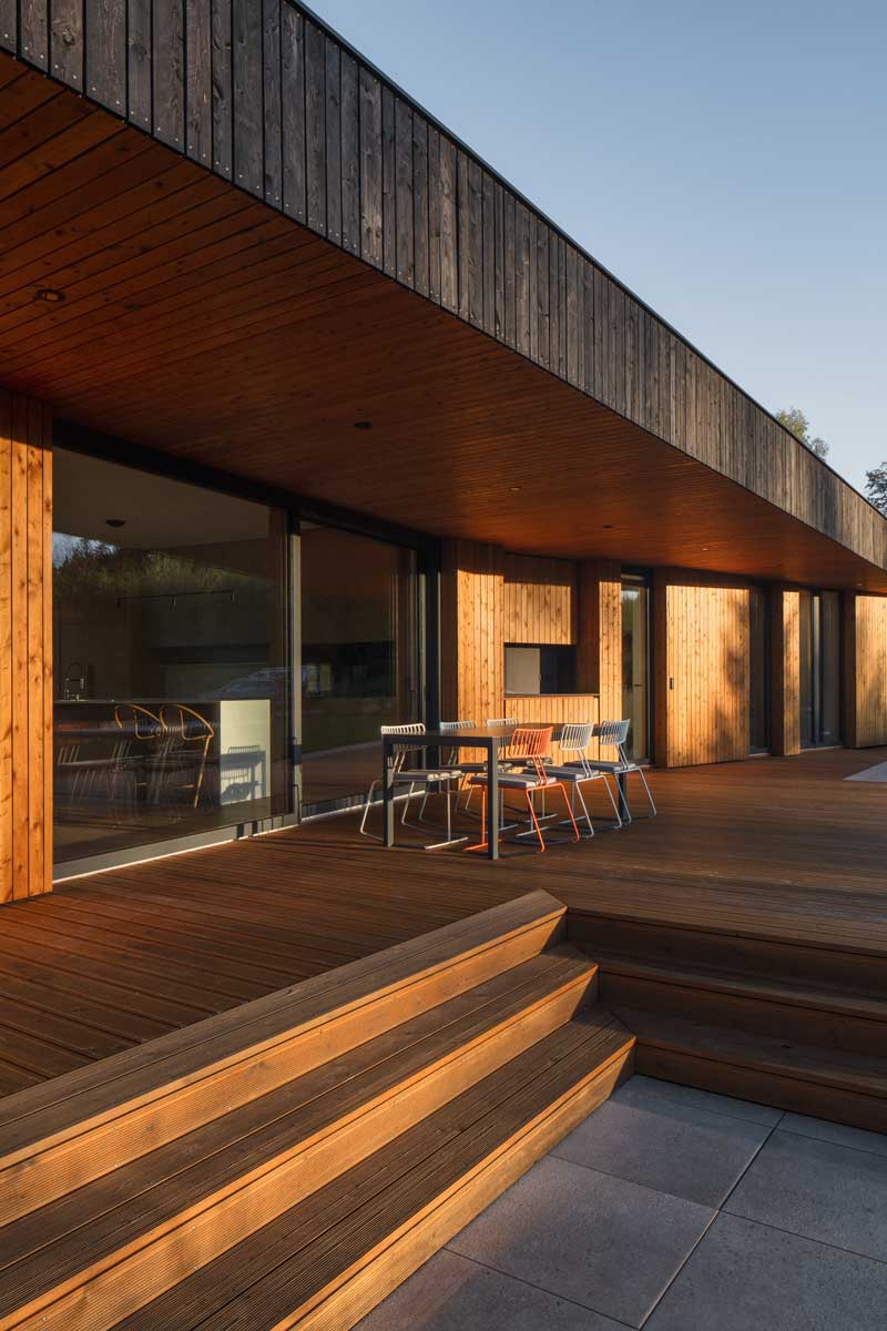Dřevěná krytá terasa s posezením a přímým propojením na obytný prostor domu