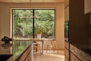 Kuchyň s mramorovým ostrůvkem, dřevěnými skříňkami a jemným osvětlením