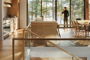 Otevřený prostor kuchyně a jídelny s dřevěným stropem a velkými okny