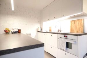 Jídelní pult s vestavěnou knihovnou a pohledem do kuchyňského koutu.