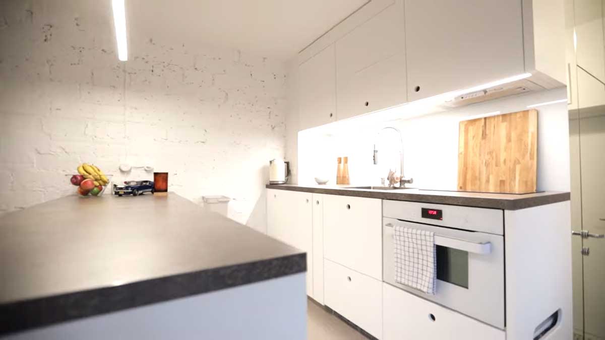 Jídelní pult s vestavěnou knihovnou a pohledem do kuchyňského koutu.