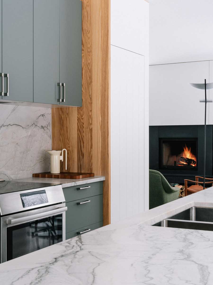 Detail kuchyňské linky s mramorovou deskou a dřevěnými akcenty působí harmonicky.