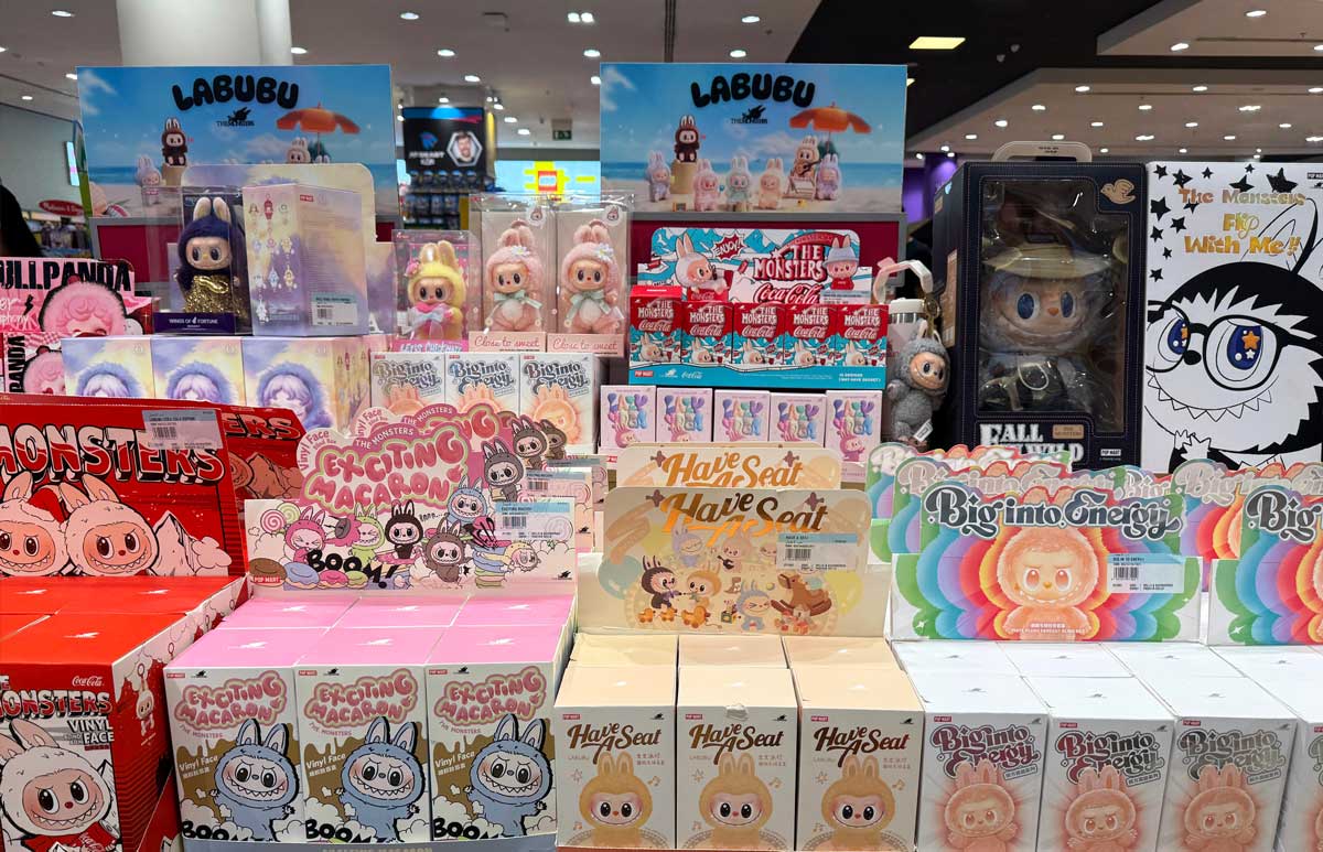 Regály plné blind boxů a figurek Labubu v prodejně s barevnými obaly.