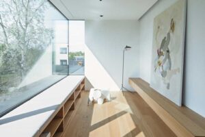 Světlem zalitý kout s dlouhou vestavěnou lavicí u panoramatického okna s výhledem do okolí.