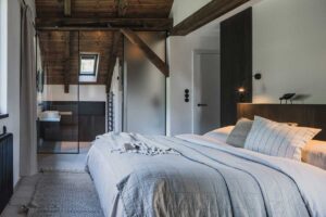 Ložnice s vlastní koupelnou propojená sklem a dřevěnými prvky