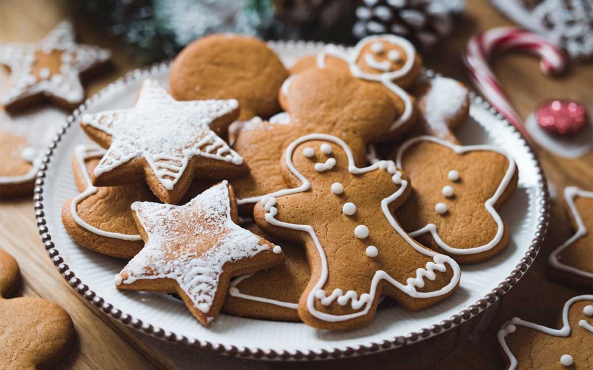 Talíř měkkých perníčků zdobených bílou polevou, připravených k podávání o Vánocích.