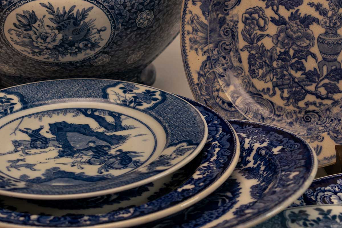Modrý porcelán v různých motivech, kde se mísí květiny, krajiny i symbolika starých kultur