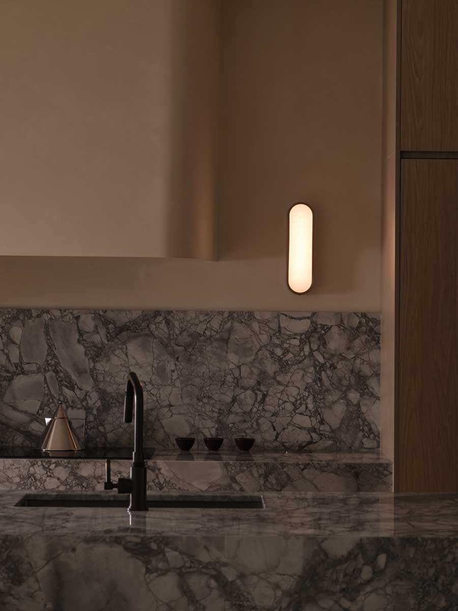 Mramorové umyvadlo s černou baterií v minimalistické koupelně