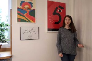 Detailní pohled na galerii plakátů umístěných na hlavní stěně garsonky.