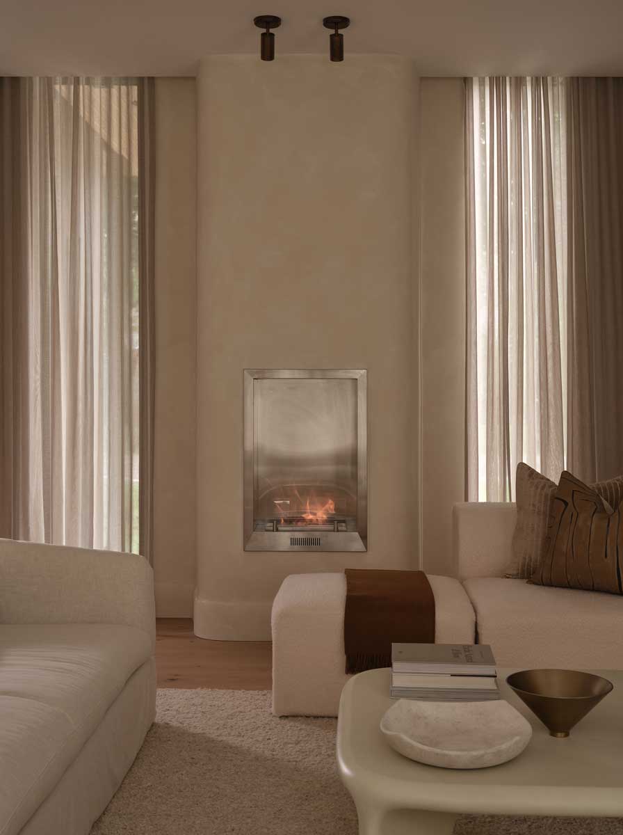 Detail moderního krbu se zaoblenou stěnou v minimalistickém obývacím prostoru