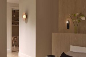 Pohled z ložnice do chodby s dřevěnými obklady a jemným nástěnným osvětlením