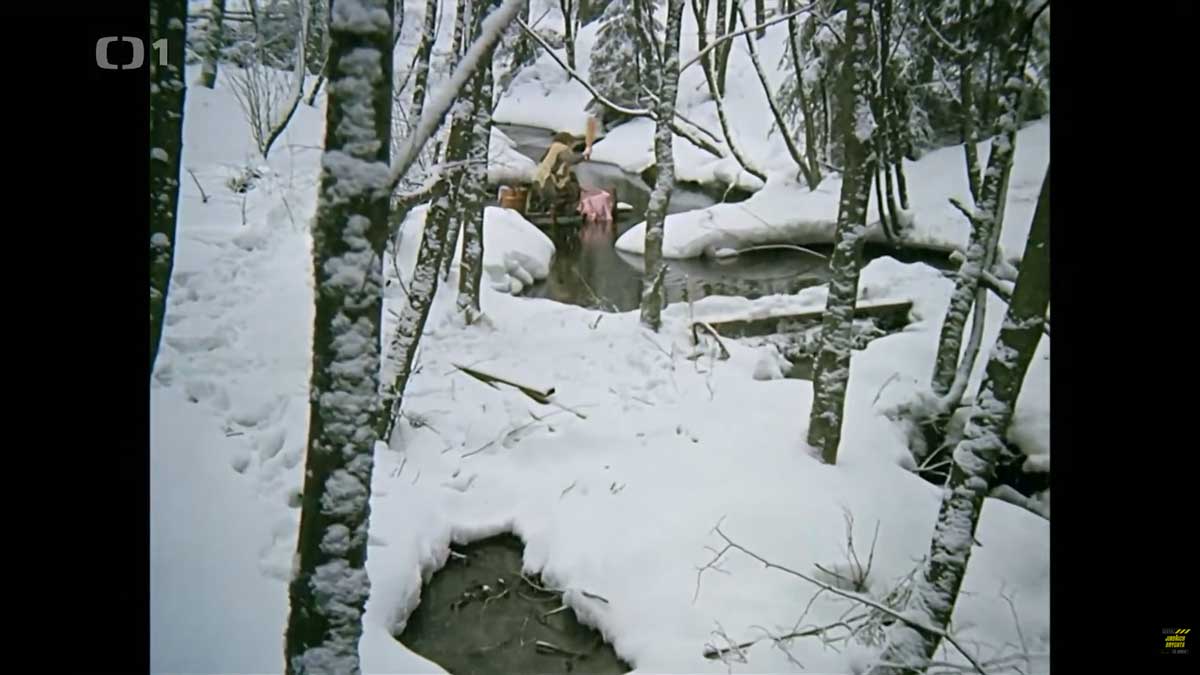 Popelka pere prádlo u potoka v zimní krajině