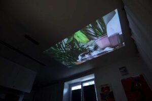 Projekce filmu na strop garsonky místo klasické televize.