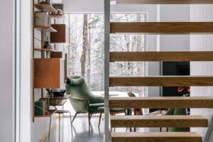 Otevřené dřevěné schodiště propouští světlo a navazuje na moderní charakter domu.