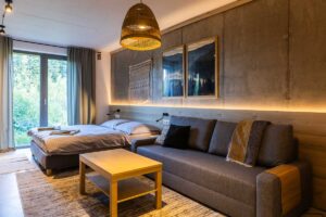 Ložnice se sedačkou a dřevěným obložením v moderní horské chatě