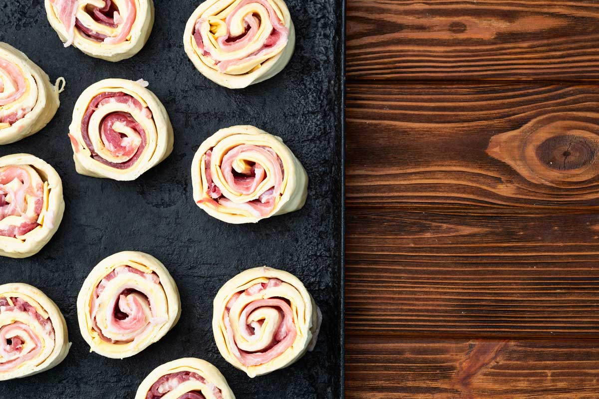 Syrové šneky z listového těsta plněné šunkou a sýrem připravené k pečení