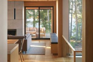 Denní zóna s velkými okny a výhledem do lesa a kuchyně