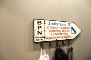 Turistická směrovka upravená jako věšák na ručníky v koupelně garsonky.