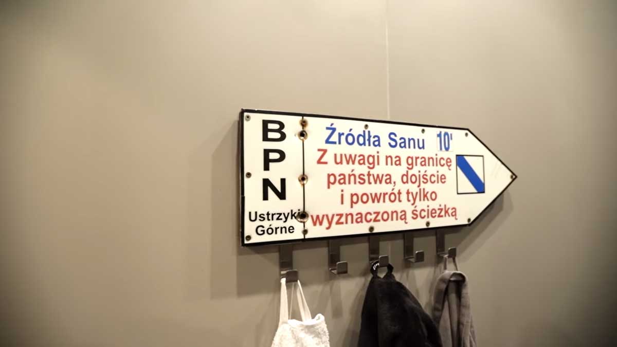 Turistická směrovka upravená jako věšák na ručníky v koupelně garsonky.