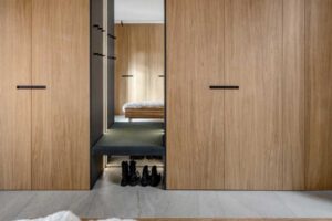 Vestavěná šatna z dubového dřeva s osvětlenou nikou a zrcadlem.