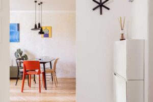 Minimalistický závěsný botník ve vstupní chodbě malého bytu.