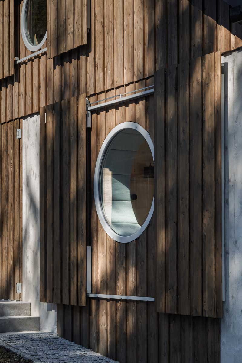 Detail kruhového okna v dřevěné fasádě šumavské chalupy