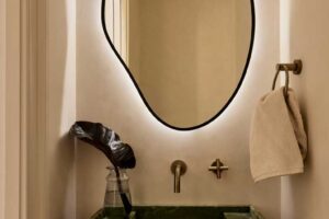 Atypické zrcadlo a kamenné umyvadlo v koupelně