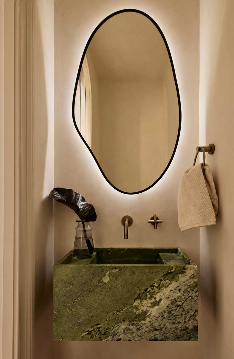 Atypické zrcadlo a kamenné umyvadlo v koupelně