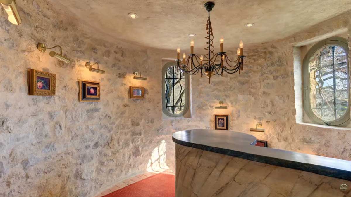 Kamenná chodba historického sídla Brigitte Bardot na Francouzské riviéře s původními kamennými zdmi a intimním osvětlením