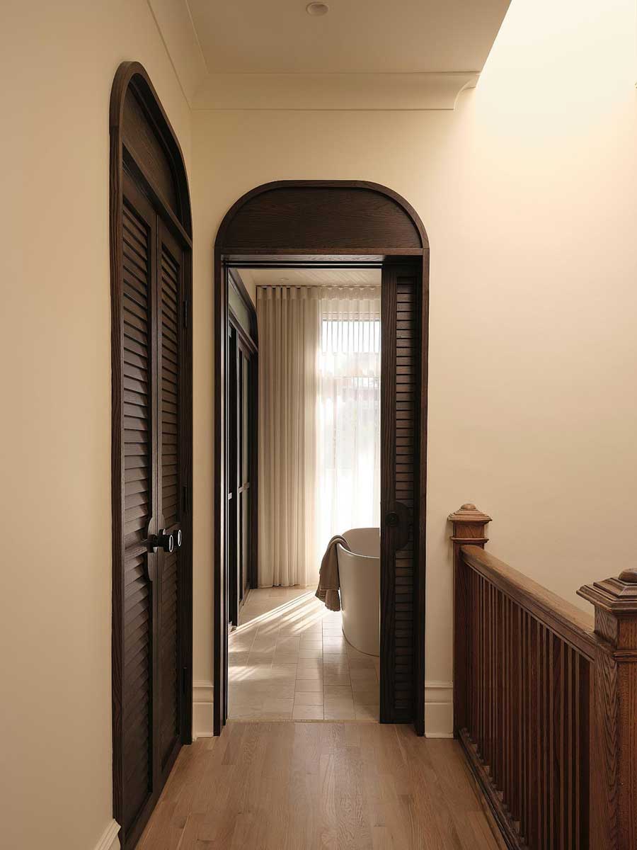 Chodba s oblým dveřním otvorem vedoucím do koupelny v rekonstruovaném domě