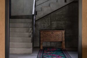 Betonové schodiště v domě Ridnyj kombinující surový beton, dřevo a kovové prvky