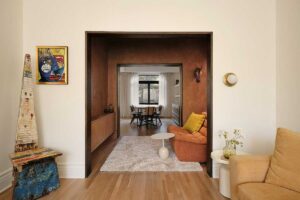 Denní zóna rodinného domu s průhledy do dalších místností a teplnou barevností interiéru