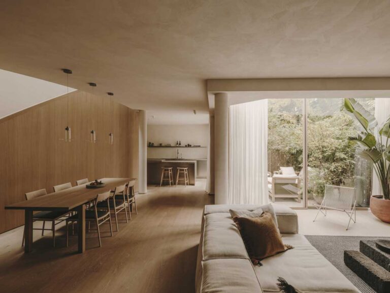 Obývací a jídelní prostor s velkými prosklenými plochami orientovanými do soukromého dvora