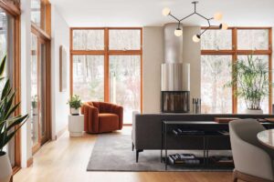 Denní zóna s velkorysými okny přirozeně propojuje interiér s okolní přírodou