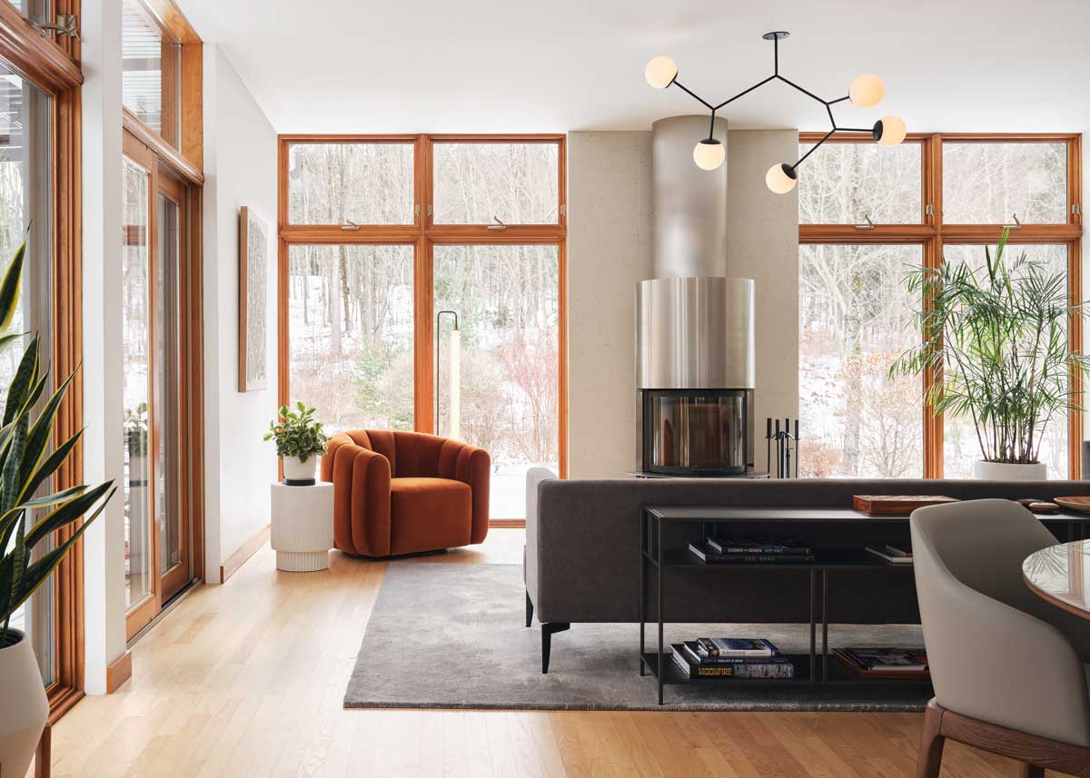 Denní zóna s velkorysými okny přirozeně propojuje interiér s okolní přírodou