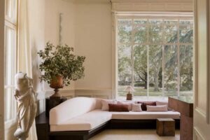 Denní zóna s rohovou sedačkou, vysokými okny a výhledem do zahrady